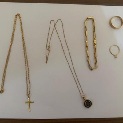 7 / DESCRIÇÃO: UM PINGENTE DOURADO COM UM PINGENTE EM FORMA DE CRUZ DOURADO; DUAS ALIANÇAS DOURADAS; DOIS ANÉIS DOURADOS; UMA PULSEIRA DOURADA E UM COLAR DOURADO COM UM PINGENTE, NO ESTADO EM QUE SE ENCONTRA.